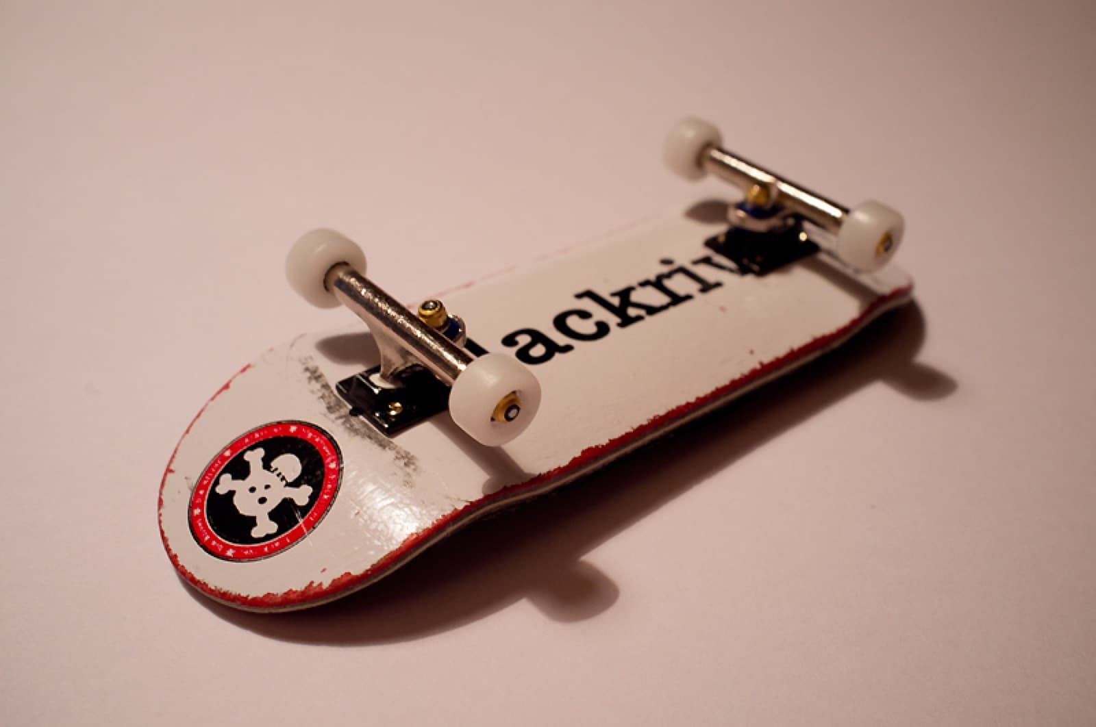 A professional fingerboard complete setup with a wooden deck, metal trucks, and wheels.
