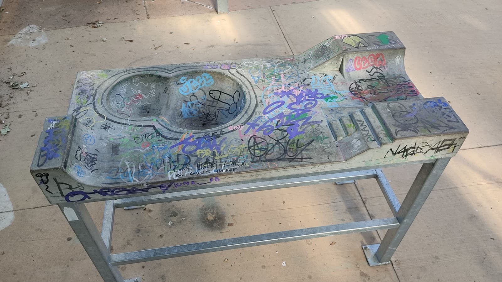 A purpose-built fingerskate practice table with obstacles at a skatepark.
